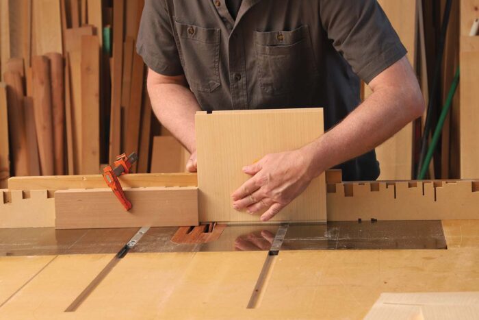 A piece of wood is held on end again and pushed over the blade using a sled.