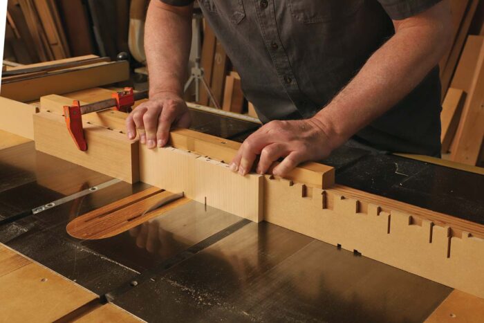 A smaller piece is being notched at the table saw.