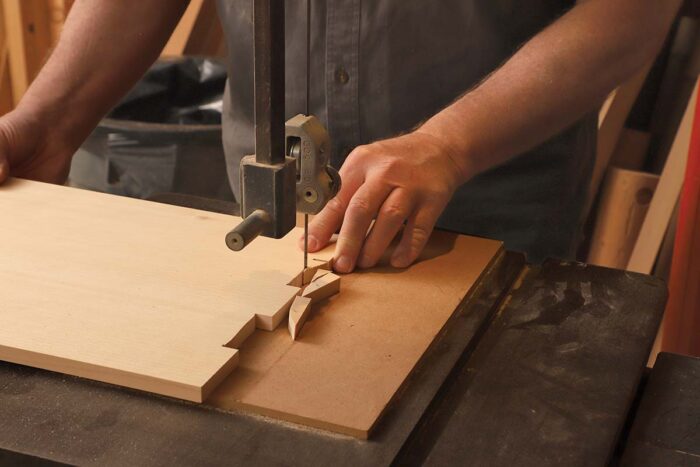 The area between the finger joints are being removed at the bandsaw.