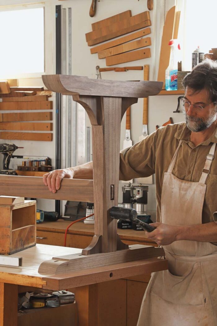 Tom uses a mallet to join the trestle lg to the stretcher. 