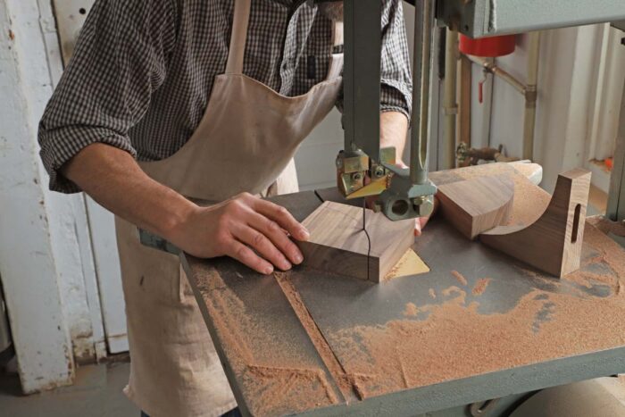 Tom uses the bandsaw to cut the profile of the corbel.