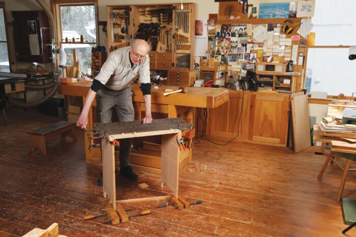 Chris uses three bar clamps to clamp the sides to the top.