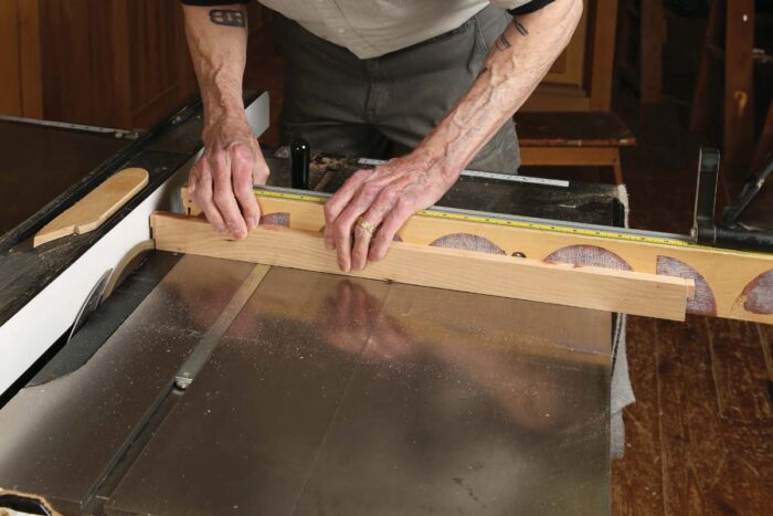 Chris uses a miter gauge to cut notches out of the dovetailed ends of each of the dividers.