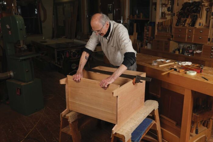 Chris slides the bottom panel into the shaker inspired side chest.