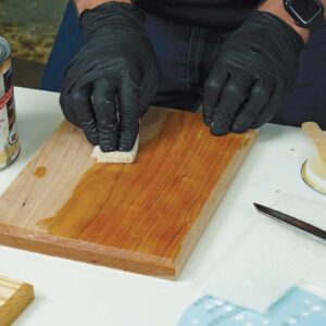 Wiping a coat of finish onto the wood.