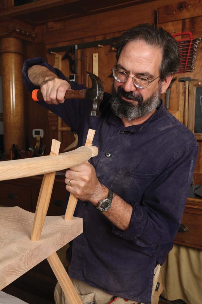 Schwarz is hammering more wedges, this time into the sticks attaching the arm. He has strange smile on his face as though he just remembered something.