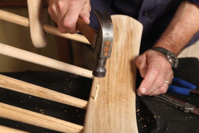 A small wooden dowel is being drilled into the hole left by the reasonably-sized drill bit from the last photo. 