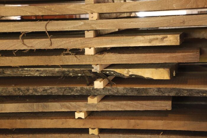 Large pieces of lumber are stacked up with milled wood between each layer.