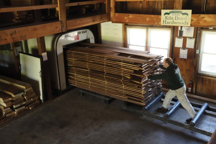 A huge stack of lumber being loaded into a commercial kiln.