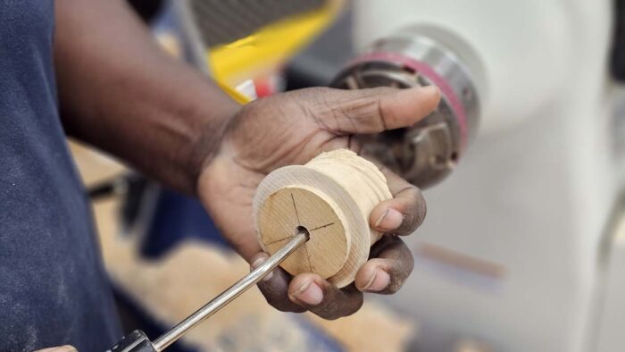 Darryl fits the end of an air compressor nozzle into the hole of the jam chuck.