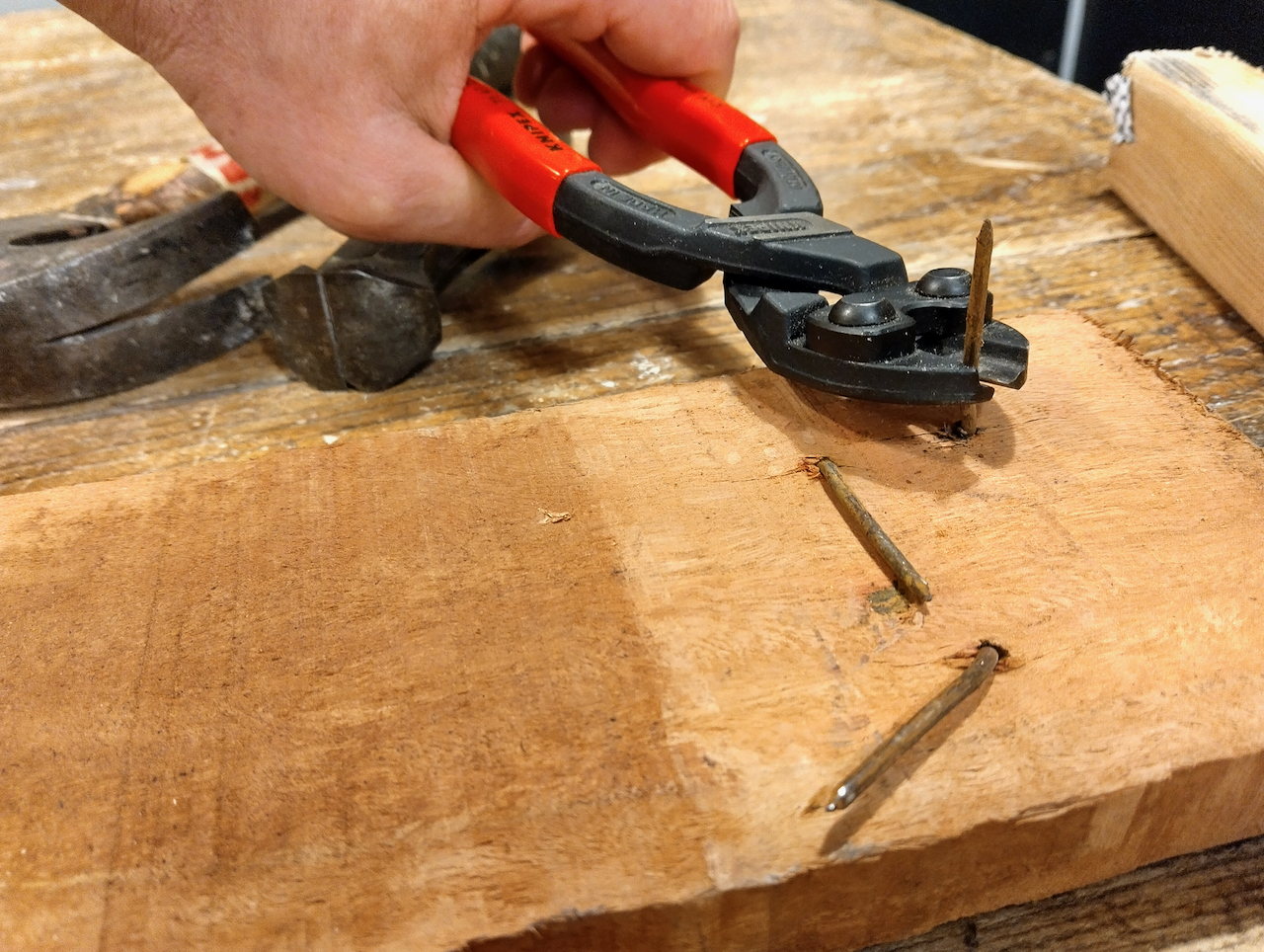 Yoav uses nippers to clip the exposed nail to about 1/2" in length.