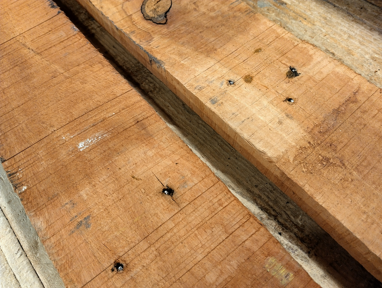 Reclaimed board with nails hammered down to expose the nail head. 