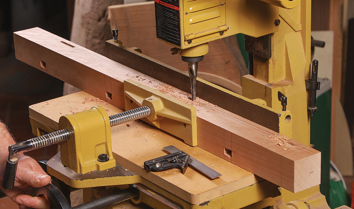 All the mortises. At his hollow-chisel mortiser, Hill chops mortises in the leg for the drawer dividers and then for the rails.